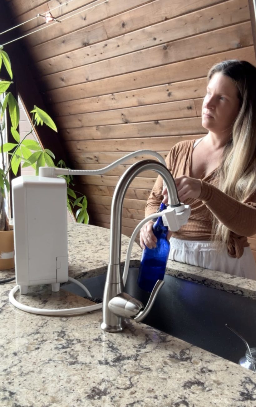 Liz filling a bottle from the electrolyzed reduced water system